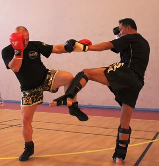 Assaut de boxe thaïlandaise en salle, coup de pied circulaire