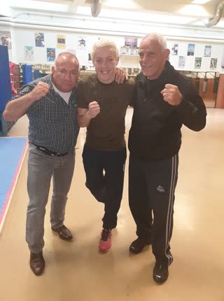 Trois pratiquants en garde de boxe dans un club